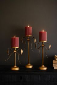 SET OF THREE ANTIQUE BRASS PILLAR CANDLE STANDS -BOW DETAIL