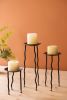 SET OF THREE RUSTIC METAL CANDLE STANDS WITH WAVY LEGS